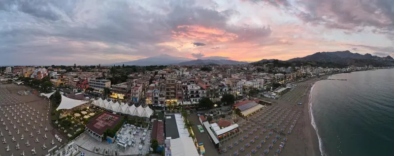 Vue panoramique d'une ville côtière au coucher du soleil.