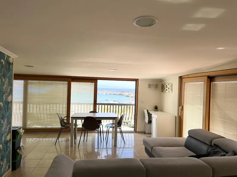 Espace de vie lumineux avec coin repas et vue sur la mer.