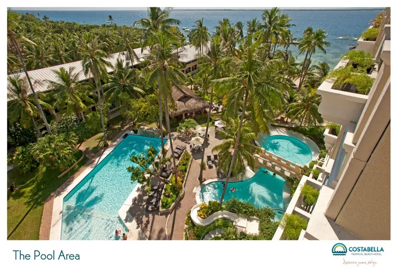 Vue aérienne d'un complexe hôtelier avec des piscines et une végétation tropicale.