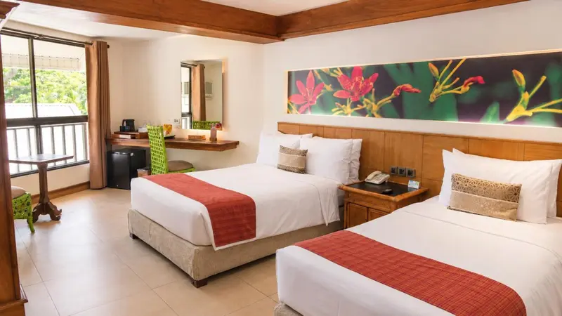 Chambre lumineuse avec deux lits et une décoration florale.
