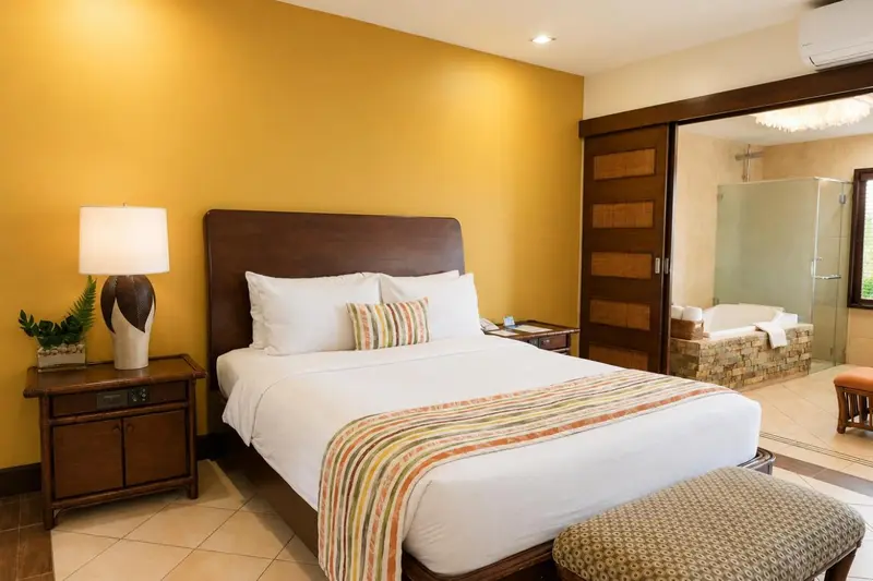 Une chambre lumineuse avec un grand lit et une salle de bain attenante.