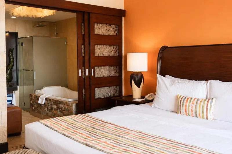 Une chambre avec un grand lit et une salle de bain attenante avec baignoire.