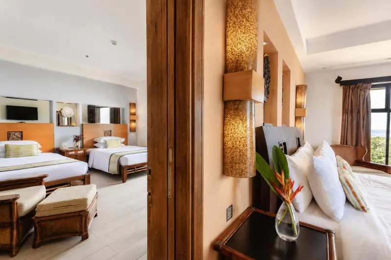 Chambre spacieuse avec deux lits et décoration chaleureuse.