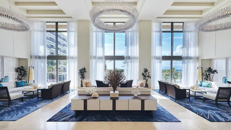 Un grand espace de détente intérieur avec des canapés et des tables basses.