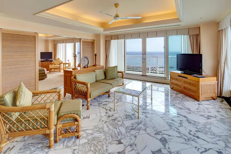 Espace de vie lumineux avec canapés et vue sur la mer.