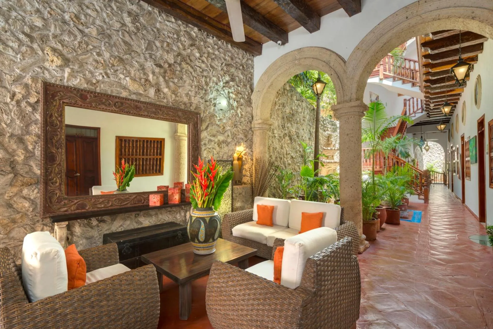 Un espace de détente intérieur avec des canapés et des fauteuils en rotin.
