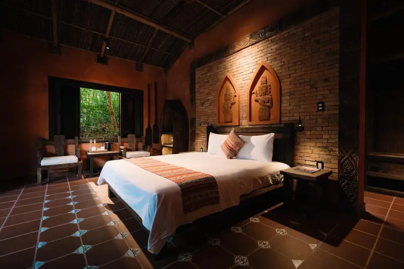 Une chambre à coucher lumineuse avec un grand lit recouvert de draps blancs.