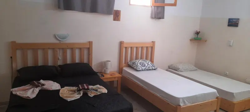 Une chambre avec deux lits simples et une couverture sur le lit principal.