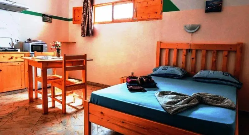 Une chambre lumineuse avec un lit et un coin repas.