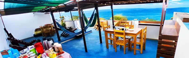 Espace de détente extérieur avec hamacs et table à manger.