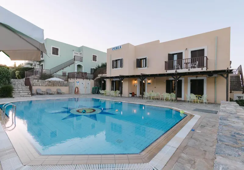 Bâtiment blanc et turquoise avec une piscine au premier plan.