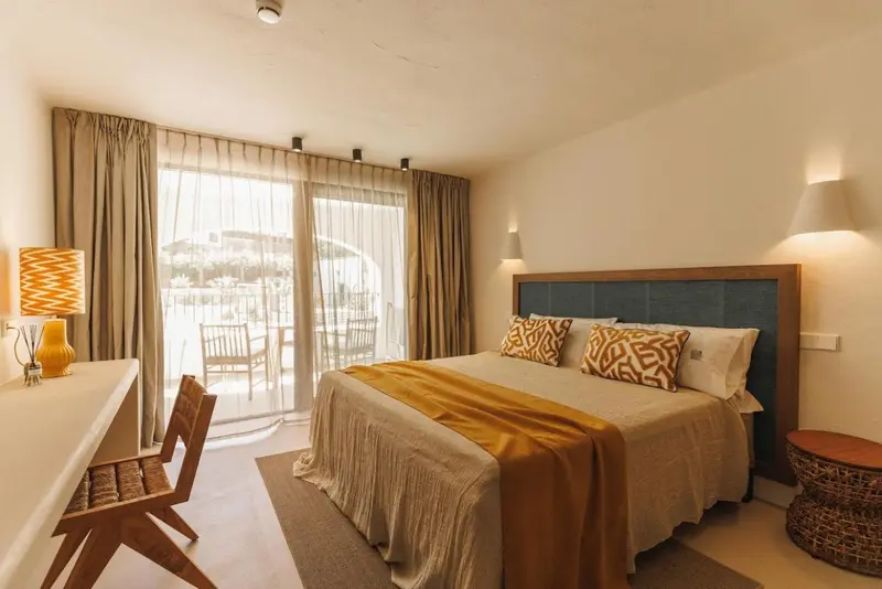 Une chambre lumineuse avec un grand lit et un accès à une terrasse.