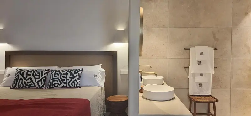 Une chambre moderne avec un grand lit et une salle de bain attenante.