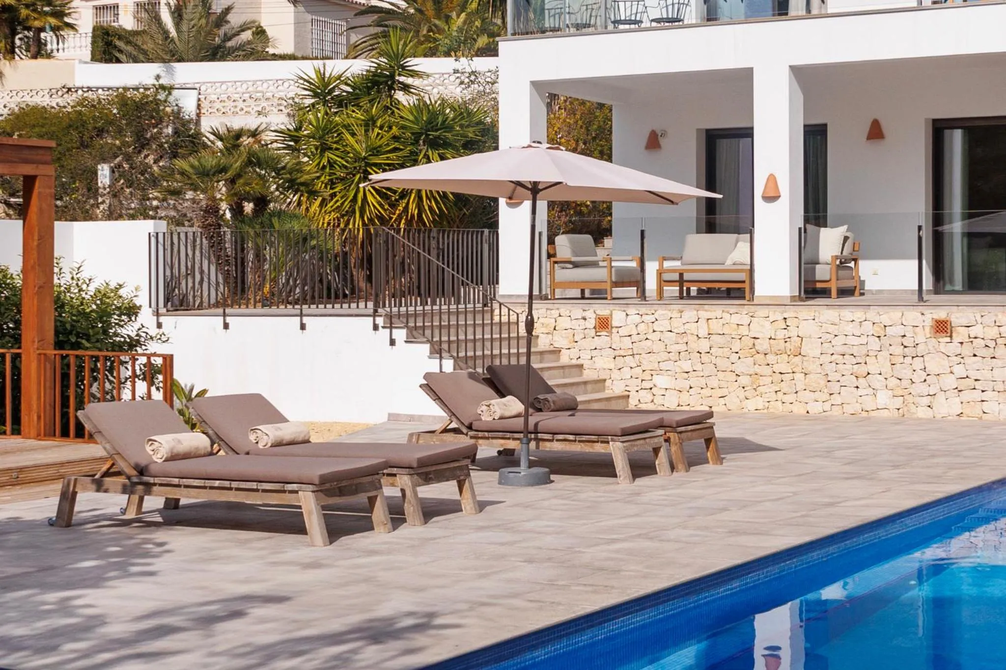Terrasse avec transats et piscine au premier plan.