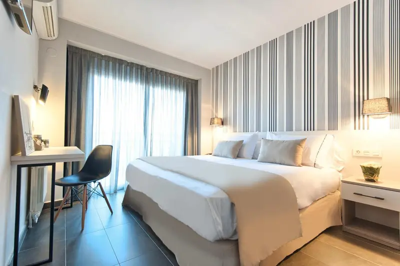 Une chambre lumineuse avec un grand lit et un bureau.