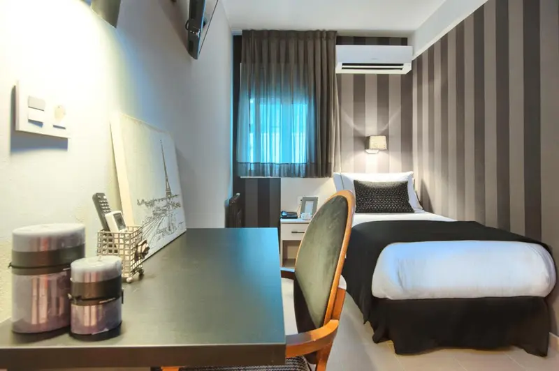 Une chambre moderne avec un lit simple et un bureau.