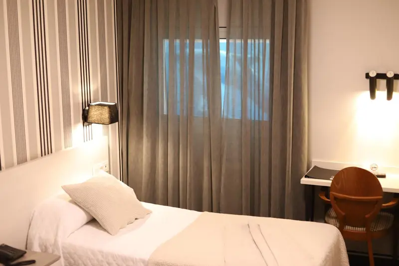 Une chambre lumineuse avec un lit simple et un bureau.