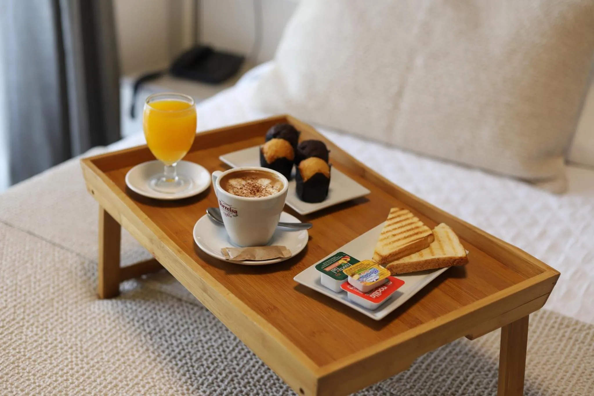 Un plateau de petit-déjeuner est posé sur un lit blanc.