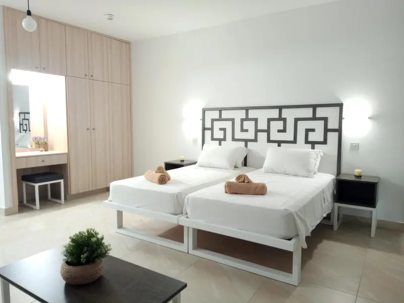 Chambre lumineuse avec deux lits simples et décoration moderne.