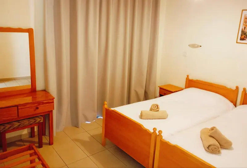 Une chambre lumineuse avec un lit et une coiffeuse en bois.