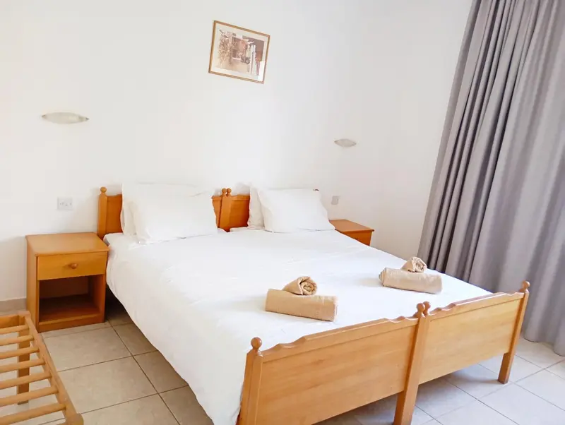 Une chambre lumineuse avec un grand lit recouvert de draps blancs.