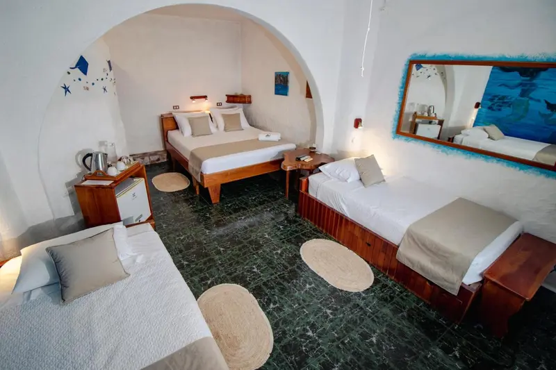 Chambre lumineuse avec lits simples et décoration marine.