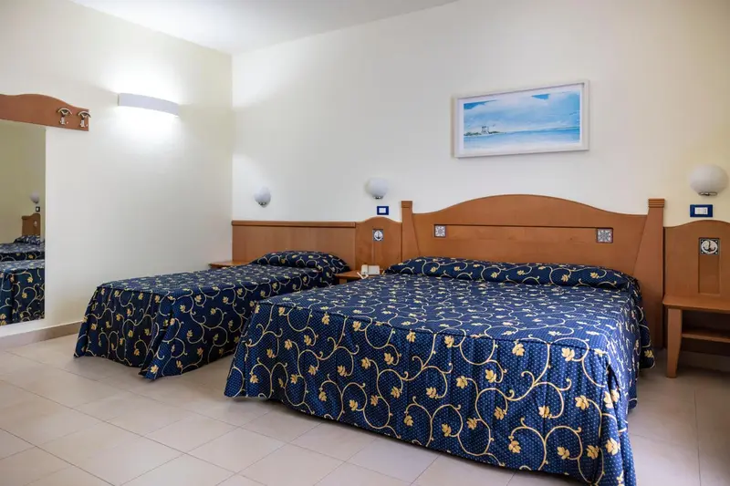 Chambre avec deux lits simples et une décoration sobre.
