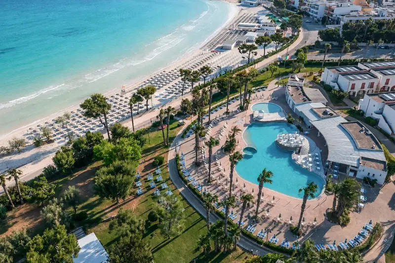 Vue aérienne d'un complexe hôtelier avec piscine et plage.