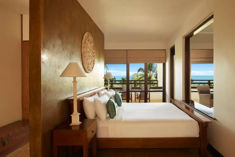 Une chambre lumineuse avec un grand lit et une vue sur la mer.