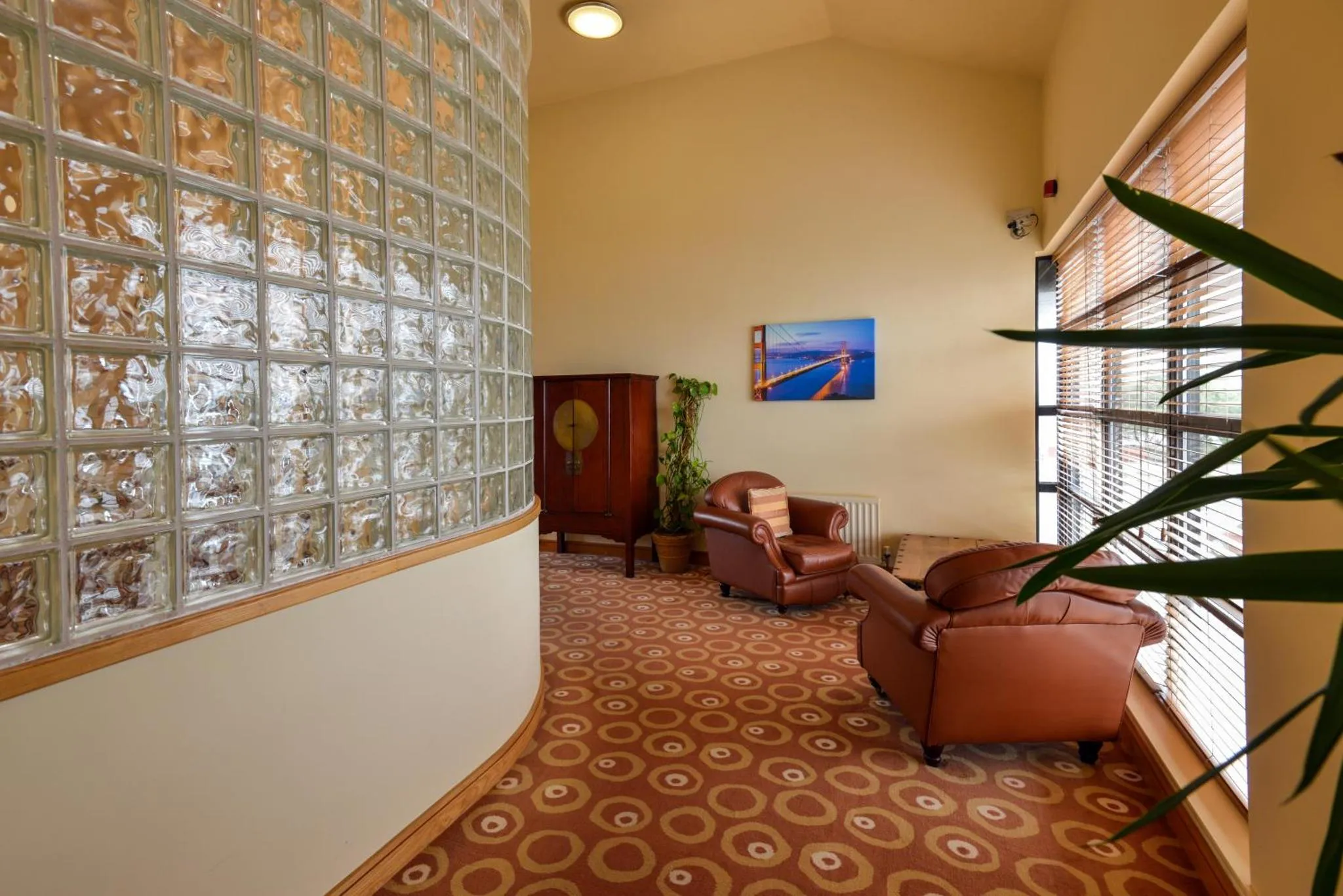 Un espace de détente intérieur avec des fauteuils et un mur en briques de verre.