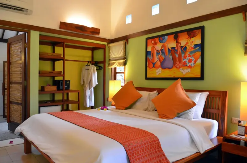 Une chambre lumineuse avec un grand lit et une décoration colorée.