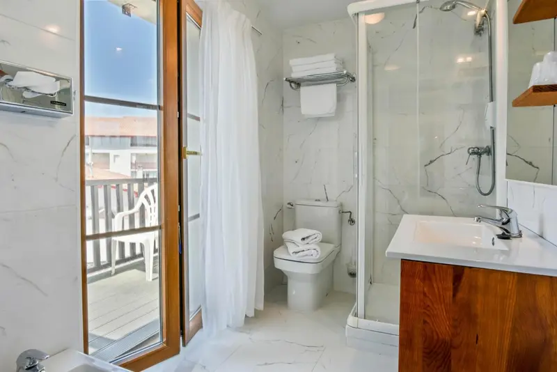Une salle de bain lumineuse avec douche à l'italienne et lavabo en bois.