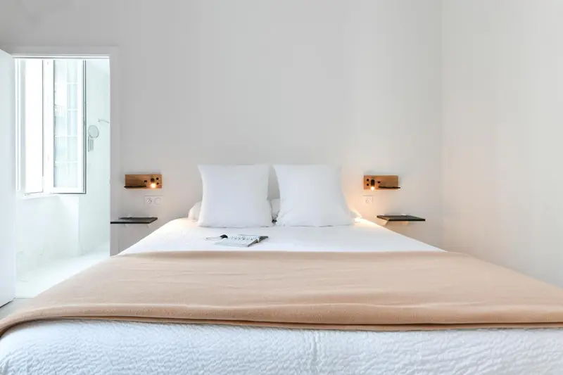 Une chambre lumineuse avec un grand lit recouvert d'une couverture.