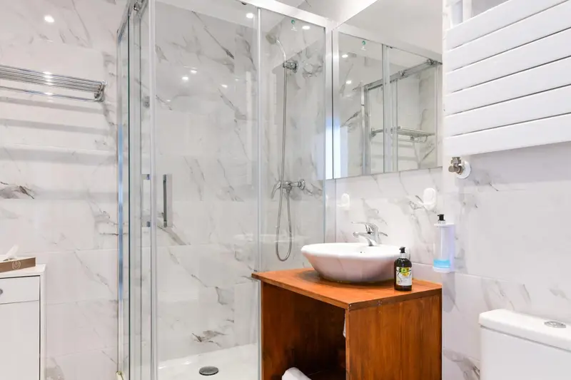Une salle de bain moderne avec douche à l'italienne et vasque sur meuble.