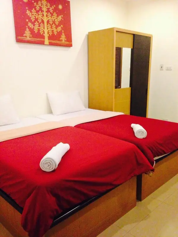 Une chambre avec deux lits simples et une décoration murale.