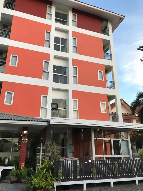 Facade d'un bâtiment orange à plusieurs étages avec des balcons.