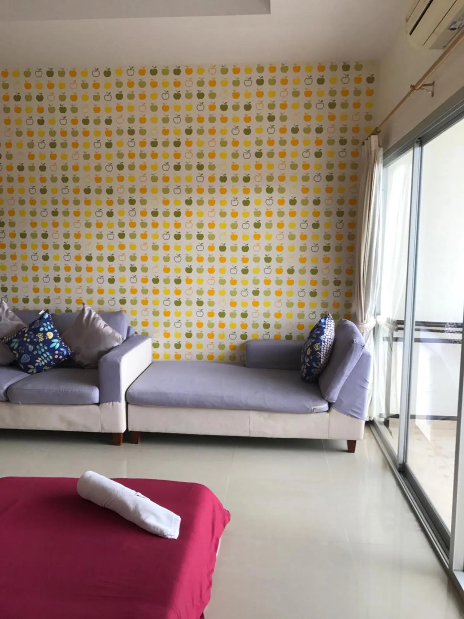 Canapé gris et coussins colorés dans un espace de détente lumineux.