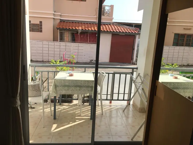 Une terrasse avec une table et des chaises en plastique.