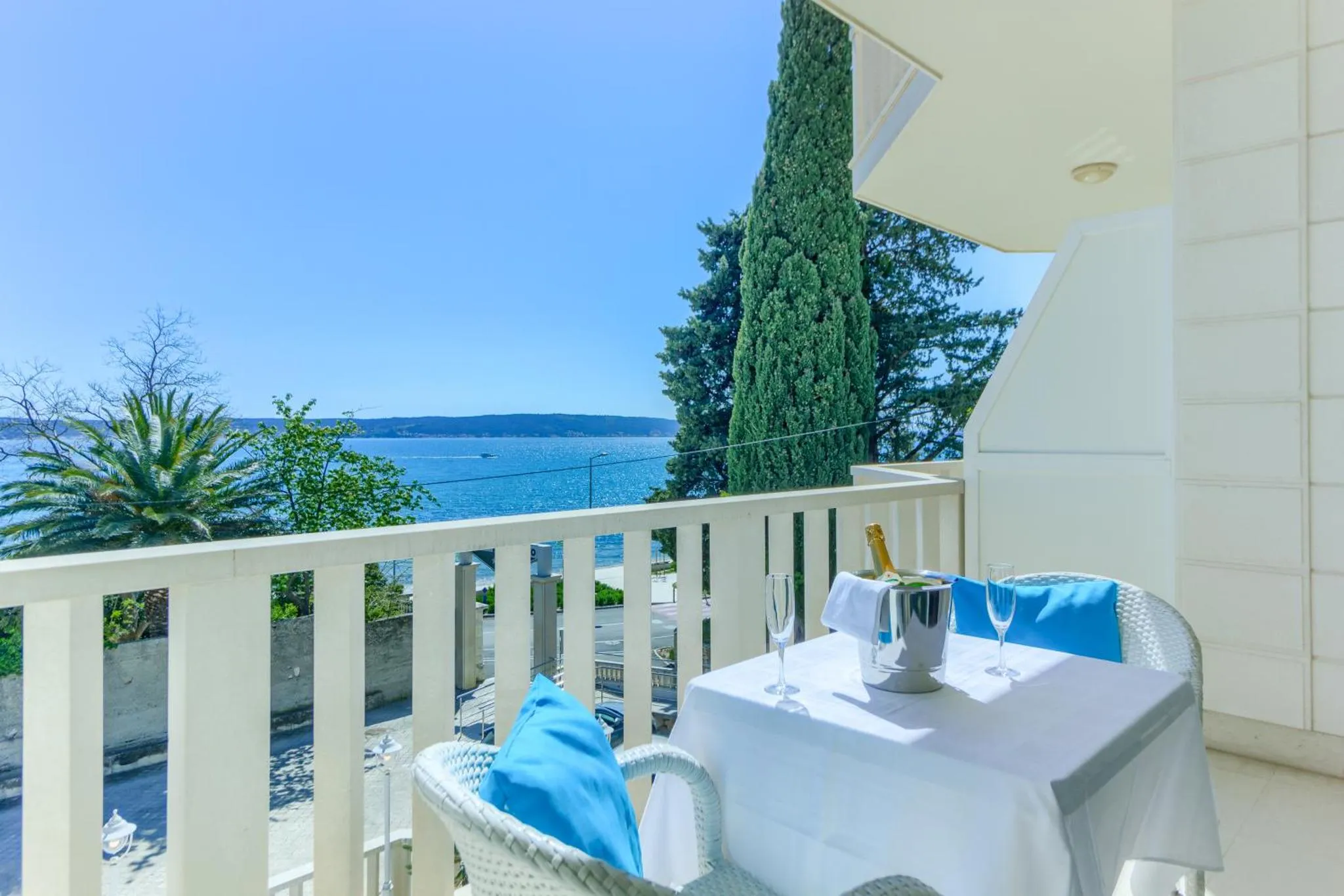 Une terrasse avec une table et des chaises offre une vue sur la mer.
