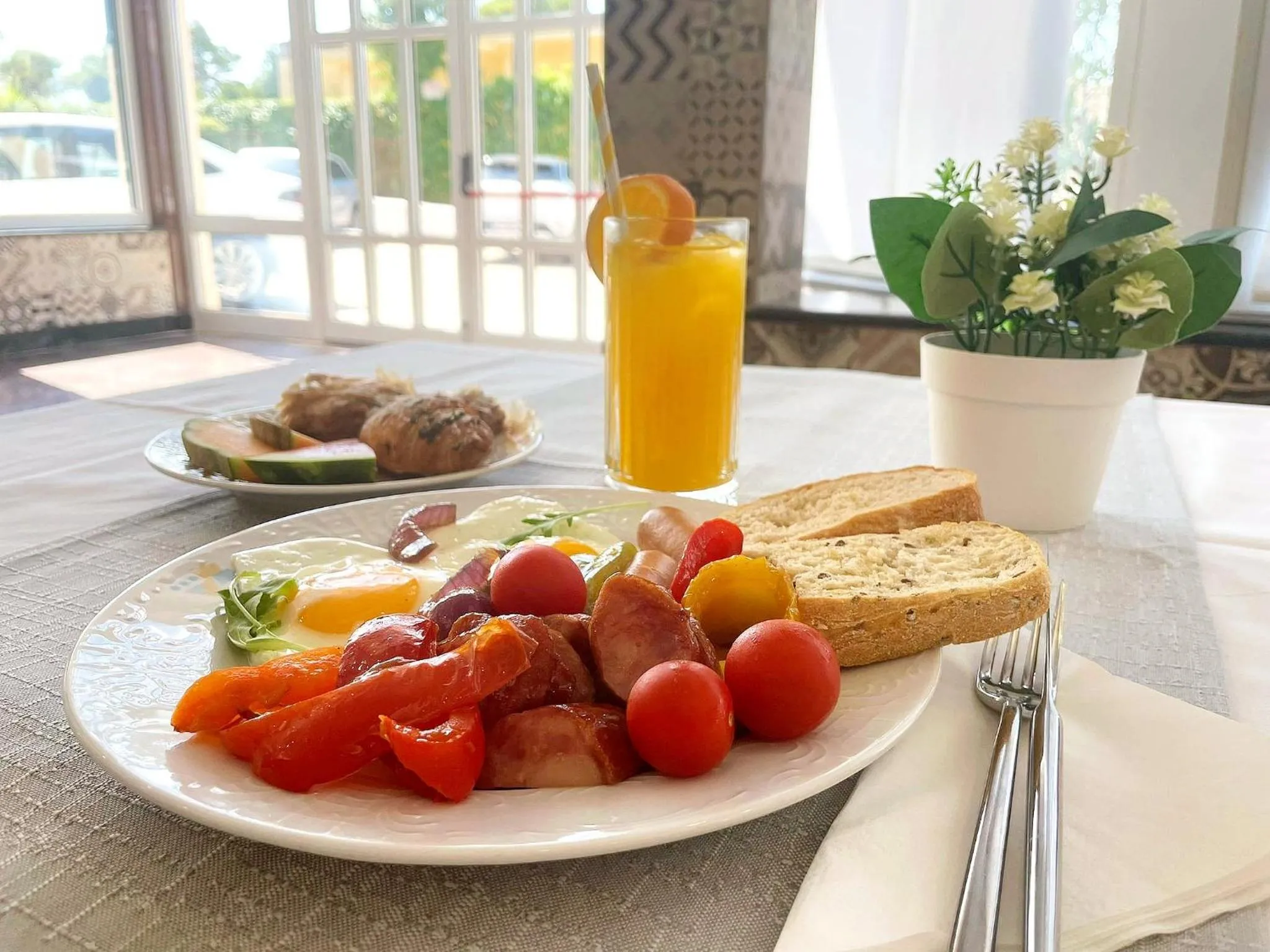 Un petit-déjeuner copieux est présenté sur une table nappée.