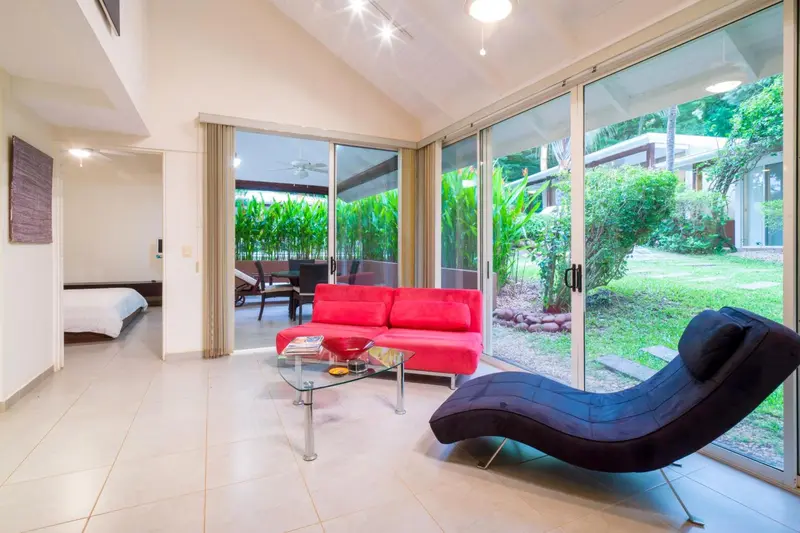 Espace de détente intérieur avec canapés et vue sur la végétation.