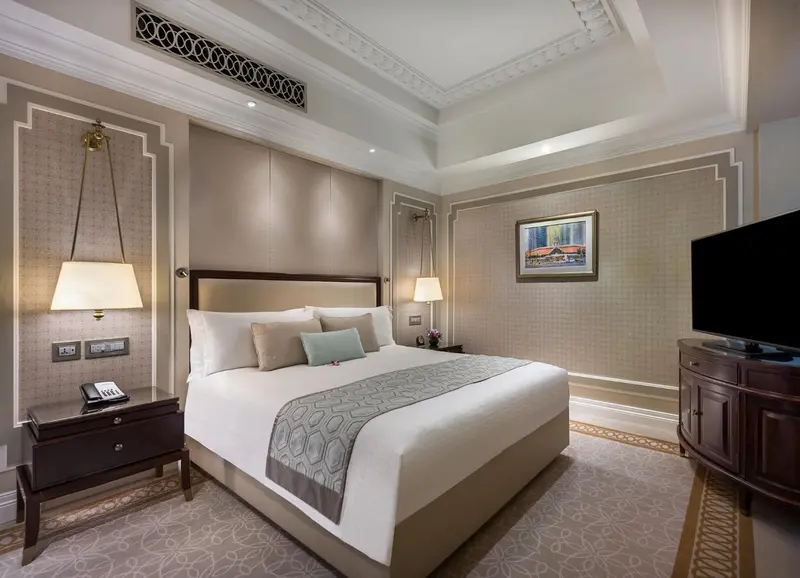 Une chambre d'hôtel élégante avec un grand lit et des meubles en bois.
