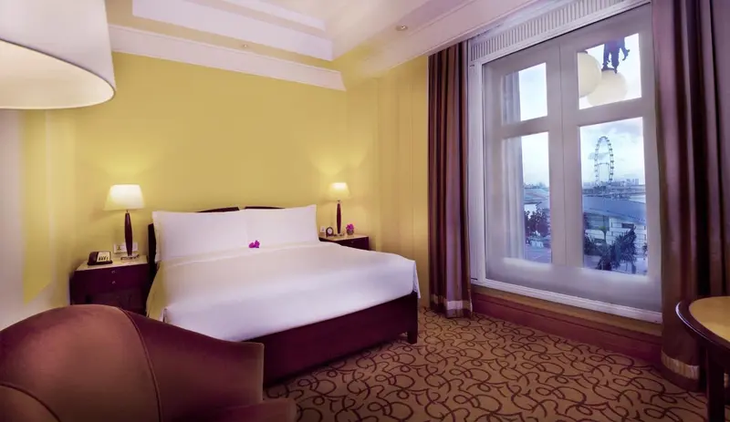 Une chambre lumineuse avec un grand lit et une vue sur la ville.