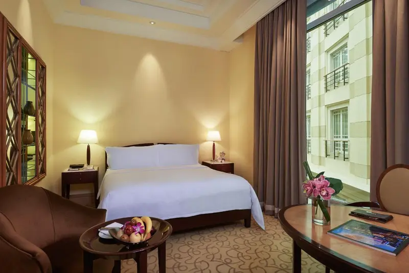Une chambre lumineuse avec un grand lit et un coin salon.