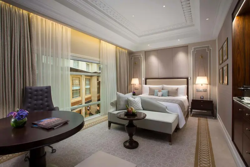 Une chambre d'hôtel élégante avec un lit à baldaquin et un coin salon.