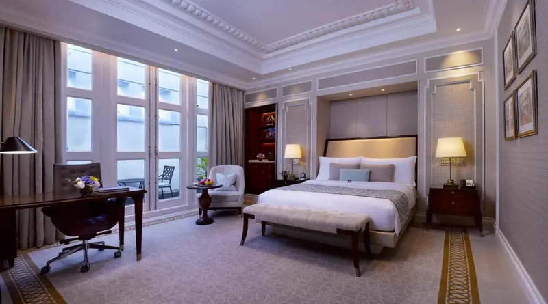 Une chambre lumineuse avec un grand lit et un bureau.