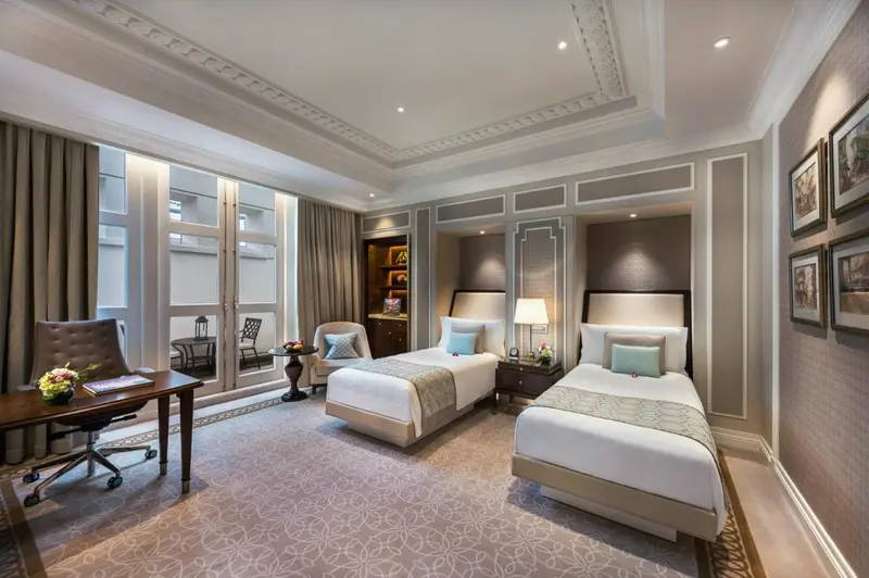 Chambre d'hôtel avec deux lits simples et un coin salon.