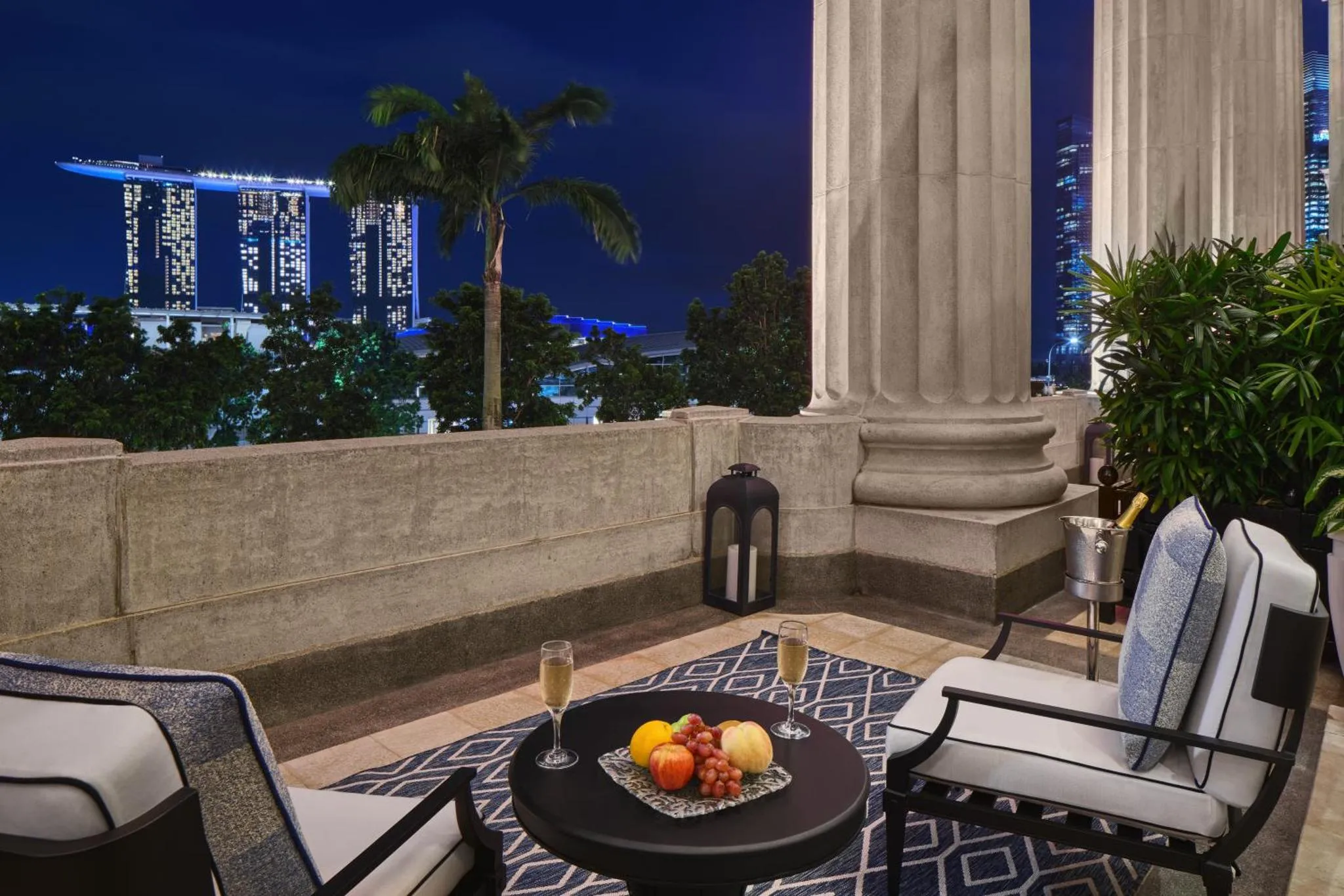 Terrasse avec mobilier d'extérieur et vue sur la ville illuminée.