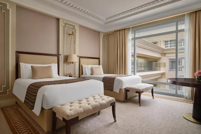 Chambre avec deux lits et une fenêtre donnant sur la ville.