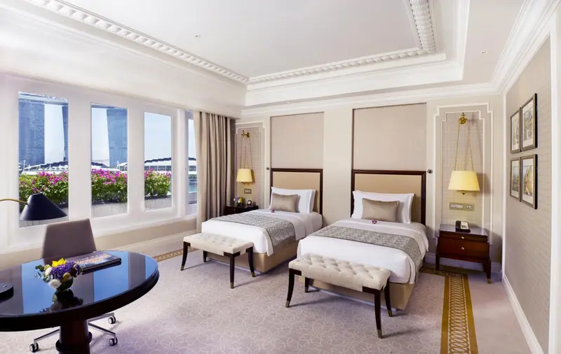 Chambre avec deux lits simples et vue sur la ville.